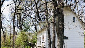 A white house with a wooden porch and a stone pathway leading to it. - In-Town Moose Haus Lodge  (Clear Lake)
