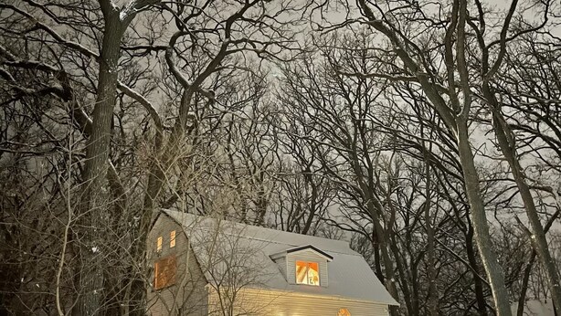 A cabin with a wooden deck and a covered porch, surrounded by trees. - In-Town Moose Haus Lodge  (Clear Lake)