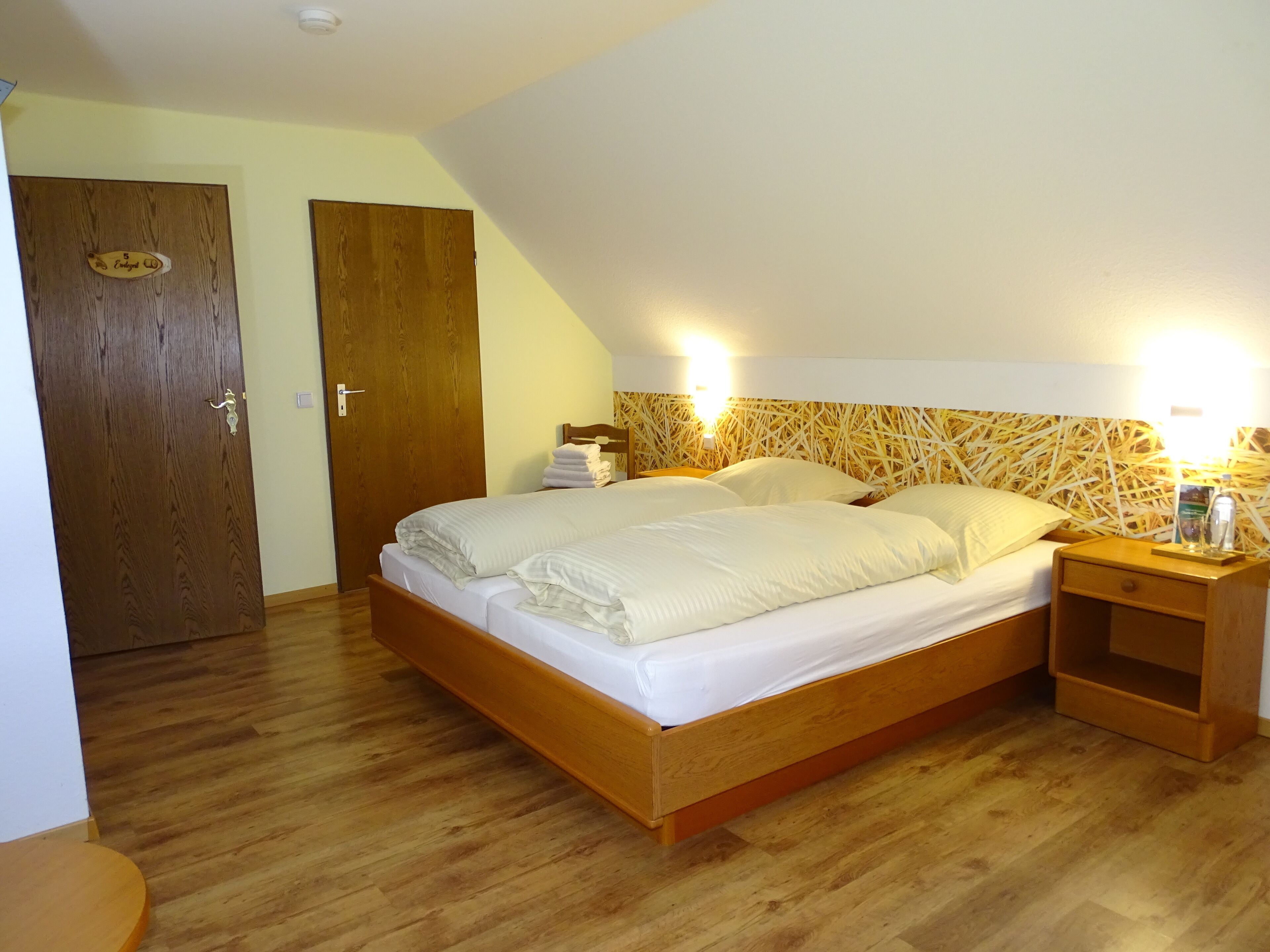Une chambre à coucher avec un lit en bois, deux tables de chevet et une petite table d’appoint.