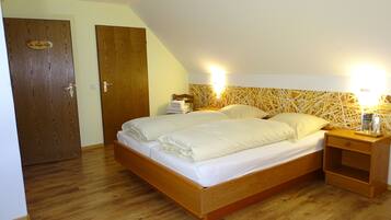 A bedroom with a wooden bed, two bedside tables, and a nightstand.