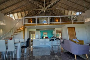 Relax in this stylish living space with a central island, dining area, and cozy seating nook.
