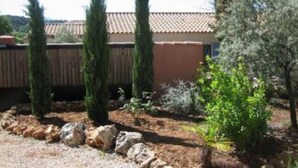 A building with a tiled roof, surrounded by a garden with cypress trees and a rock garden. - Large contemporary house with garden (Seillons-Source-d'Argens)