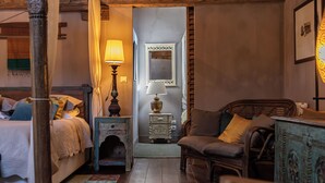 Une chambre confortable avec un lit, une table de chevet, une lampe et une petite commode.