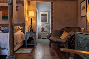 Un dormitorio acogedor con cama, mesita de noche, lámpara y un pequeño aparador.