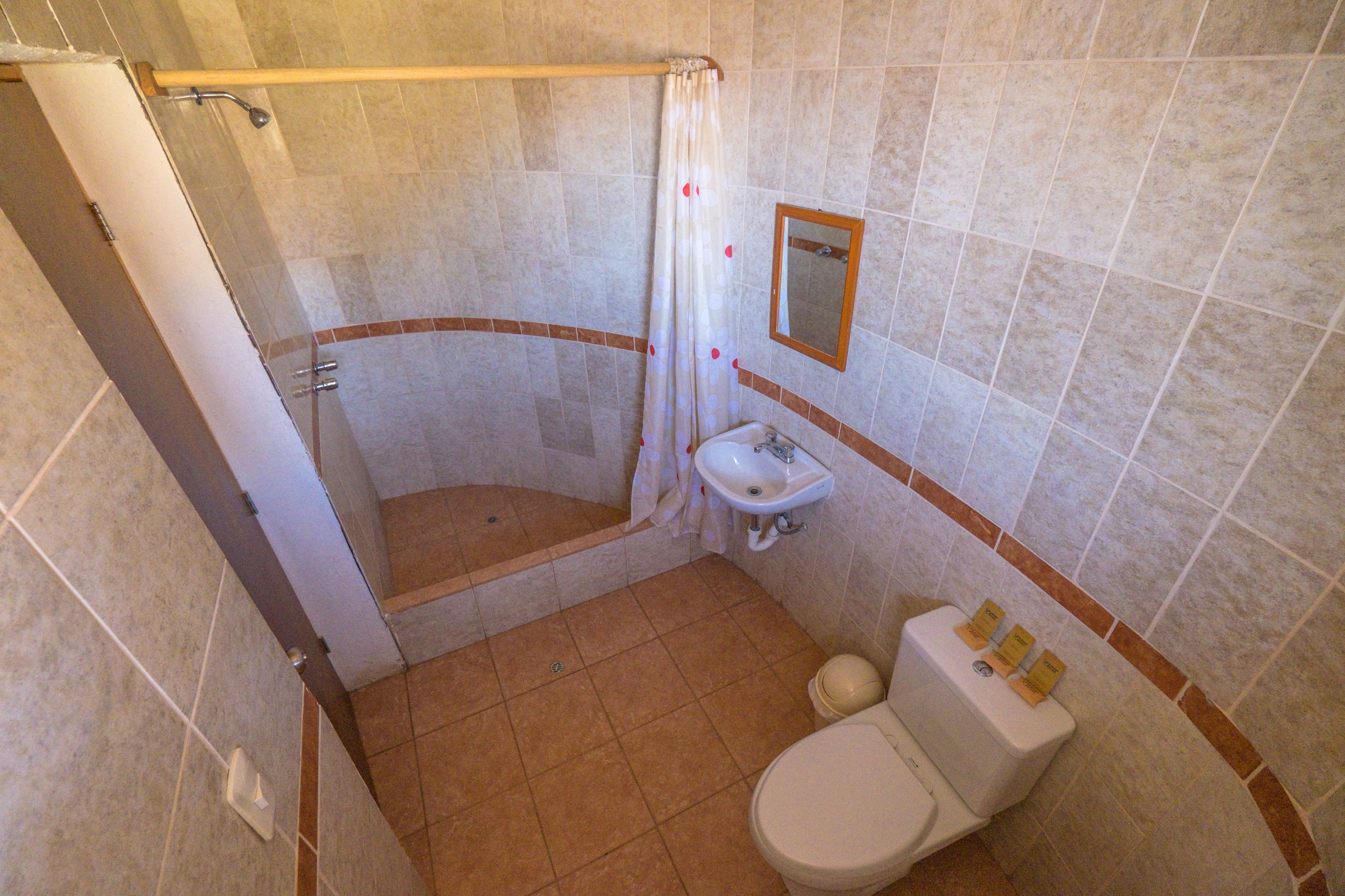 A bathroom with a shower, toilet, and sink.