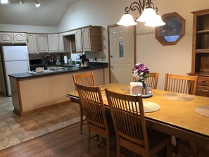 Enjoy meals in this well-equipped kitchen and dining area with oven, coffee maker, and wooden table.