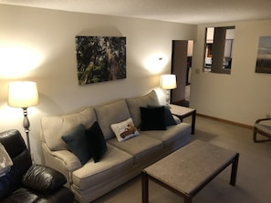 Relax in this stylish living room with a comfortable sofa, coffee table, and floor lamps.