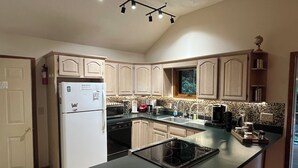 A kitchen with a refrigerator, microwave, stove, and various appliances. - Work & Play in our High Country Hideaway (Boone)