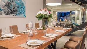 A dining area with a long wooden table set for a meal, surrounded by chairs. - Beautiful professionally managed villa, walking distance to the Hvar City center (hvar)