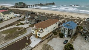 Zona residencial costera con casas, un muelle y una playa.
