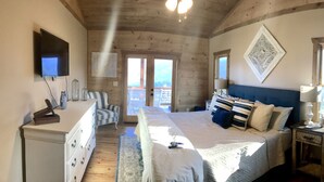 A bedroom with a bed, dresser, TV, and two windows. - Luxury cabin! Designer decorated.  Incredible views! Amazing sunrise! Secluded!  (Blue Ridge)