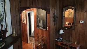 Un interior de fusta amb escriptori, làmpada i obra d'art emmarcada.