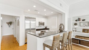 A modern kitchen with white cabinetry, stainless steel appliances, and a central island with bar stools. - Beach days made better under the brim at Beach Hat/ Gulf Views / 2 Bikes (WaterColor)