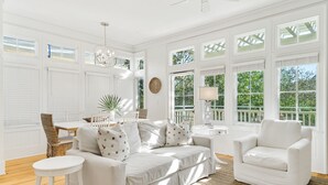 A bright, white room with large windows, a sofa, a chair, and a small table. - Beach days made better under the brim at Beach Hat/ Gulf Views / 2 Bikes (WaterColor)
