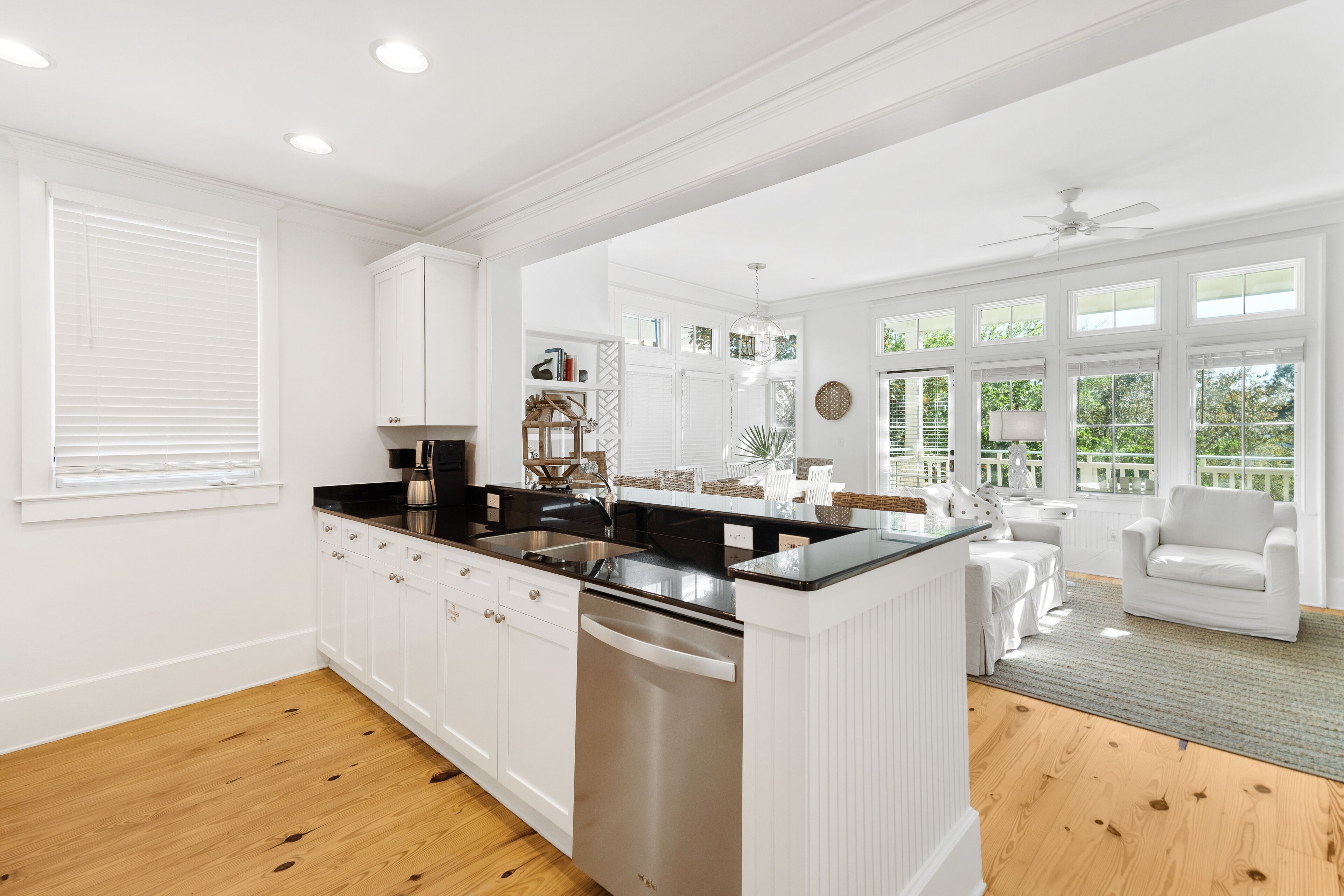 A spacious kitchen with white cabinetry, a black countertop, and a built-in dishwasher.