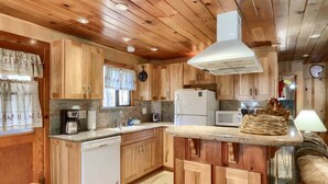 A kitchen with wooden cabinets, a dishwasher, a microwave, and a coffee maker.