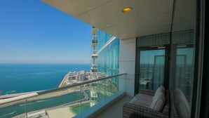 Un balcone con vista libera sull'oceano e un complesso di edifici moderni.