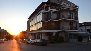 Un hotel de varios pisos con diseño arquitectónico moderno, que cuenta con balcones y grandes ventanales.