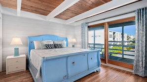 Un dormitorio con una cama grande, techo de madera y un balcón con vistas.