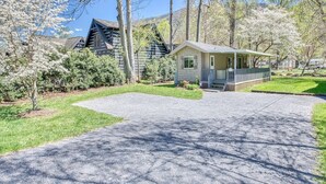 Un quartier résidentiel avec une maison dotée d’un porche, d’une allée et entourée d’arbres.