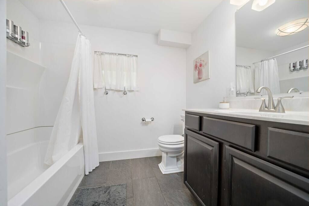 Un bagno moderno con vasca, water e lavabo.