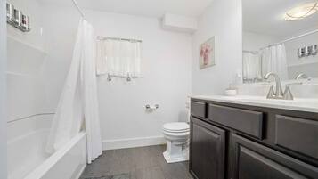 Un bagno moderno con vasca, water e lavabo.