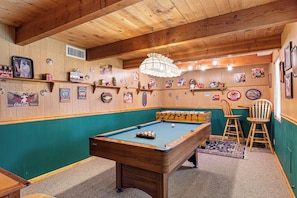 Relax by the pool table in a room filled with nostalgic memorabilia and a unique light fixture.