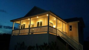 Een huis met twee verdiepingen, een balkon, een trap en een veranda.