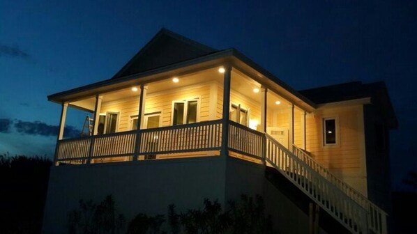 A two-story house with a balcony, a staircase, and a porch area. - CAT NAP - An Affordable Home Away from Home (Rainbow Bay)