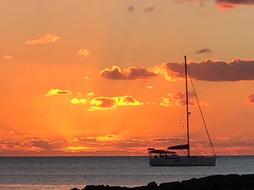 A sailboat on calm waters during sunset.