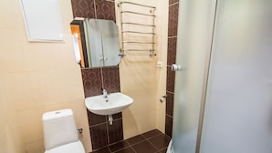 A bathroom with a toilet, sink, and a glass shower enclosure. - 1 Bedroom Apartment on Sq. Staryi Rynok 1 (Lviv)