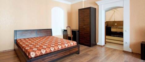 Un dormitorio con cama, escritorio y armario.