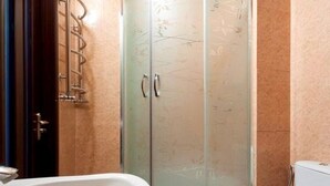 Une salle de bain avec une douche à parois de verre, un lavabo blanc et des toilettes.