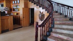 A hotel reception area with a wooden desk, a clock, and a sign that reads "Maya Mai Hotel". - Ngoc Mai Hotel (Bai Chay)