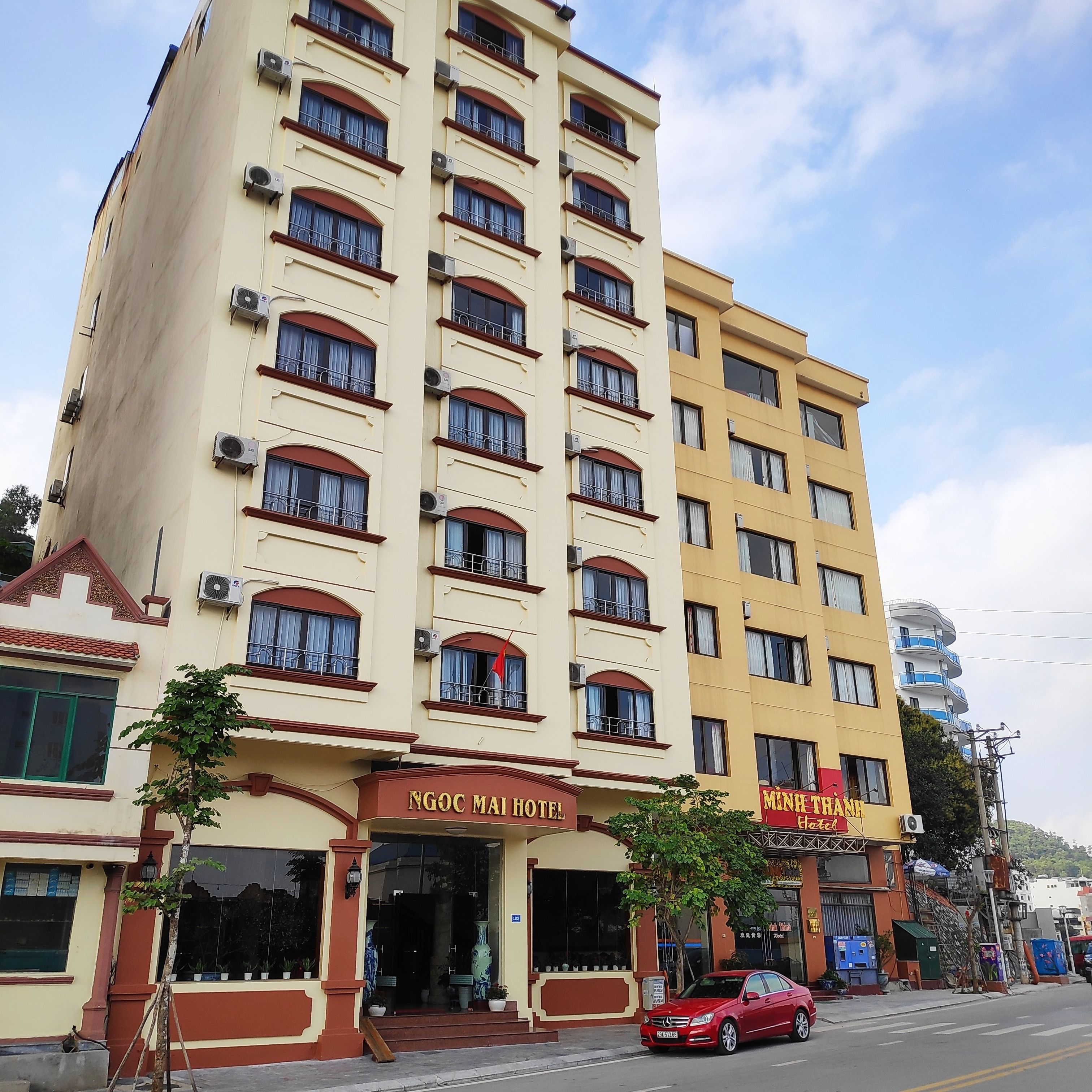 A multi-story hotel with balconies and air conditioning units.