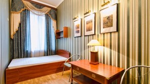 A compact room with a bed, a desk, a chair, and a lamp. - 1 Bedroom Apartment Ave. Svobody 31 (Lviv)