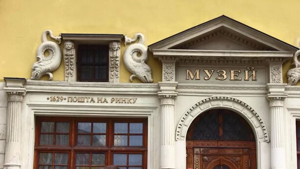 A building facade with a classical architectural style, featuring ornate carvings and a prominent entrance with a wooden door. - 1 Bedroom Apartment Valova 16A (Lviv)