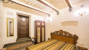 A bedroom with a wooden bed, a wardrobe, a mirror, and a staircase leading to another room. - 1 Bedroom Apartment Valova 16A (Lviv)