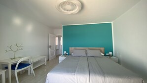 A bedroom with a bed, bedside tables, a desk, and a chair. - Molino azul 1A (Valle Gran Rey)