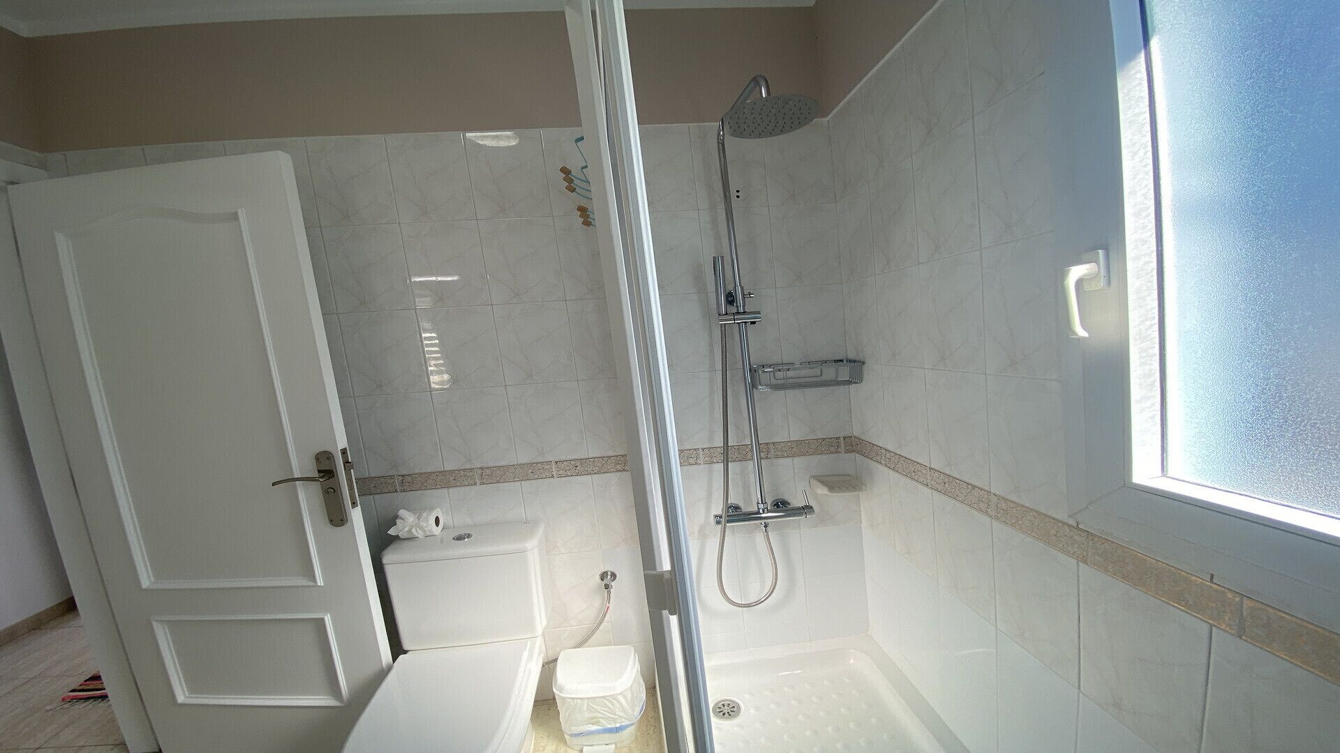 A bathroom with a shower, toilet, and sink.