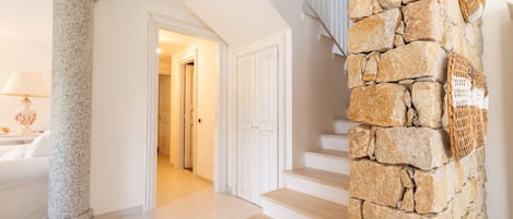 A staircase with stone steps and a column, leading to a room with a white door.
