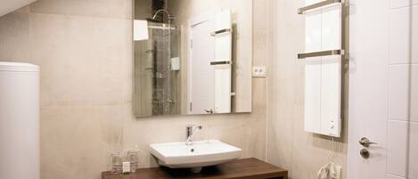 Un baño moderno con un espejo grande, un lavabo y un inodoro.