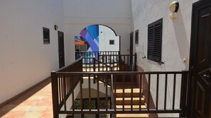 Un corridoio con una scala che conduce a una stanza decorata da un murale colorato.