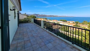 A balcony with a tiled floor, a black railing, and a view of the sea and mountains. - In Saint Florent, villa with panoramic gulf view and private pool (Sain-Florent)