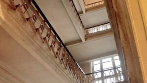 Una escalera con barandilla que lleva a un balcón.