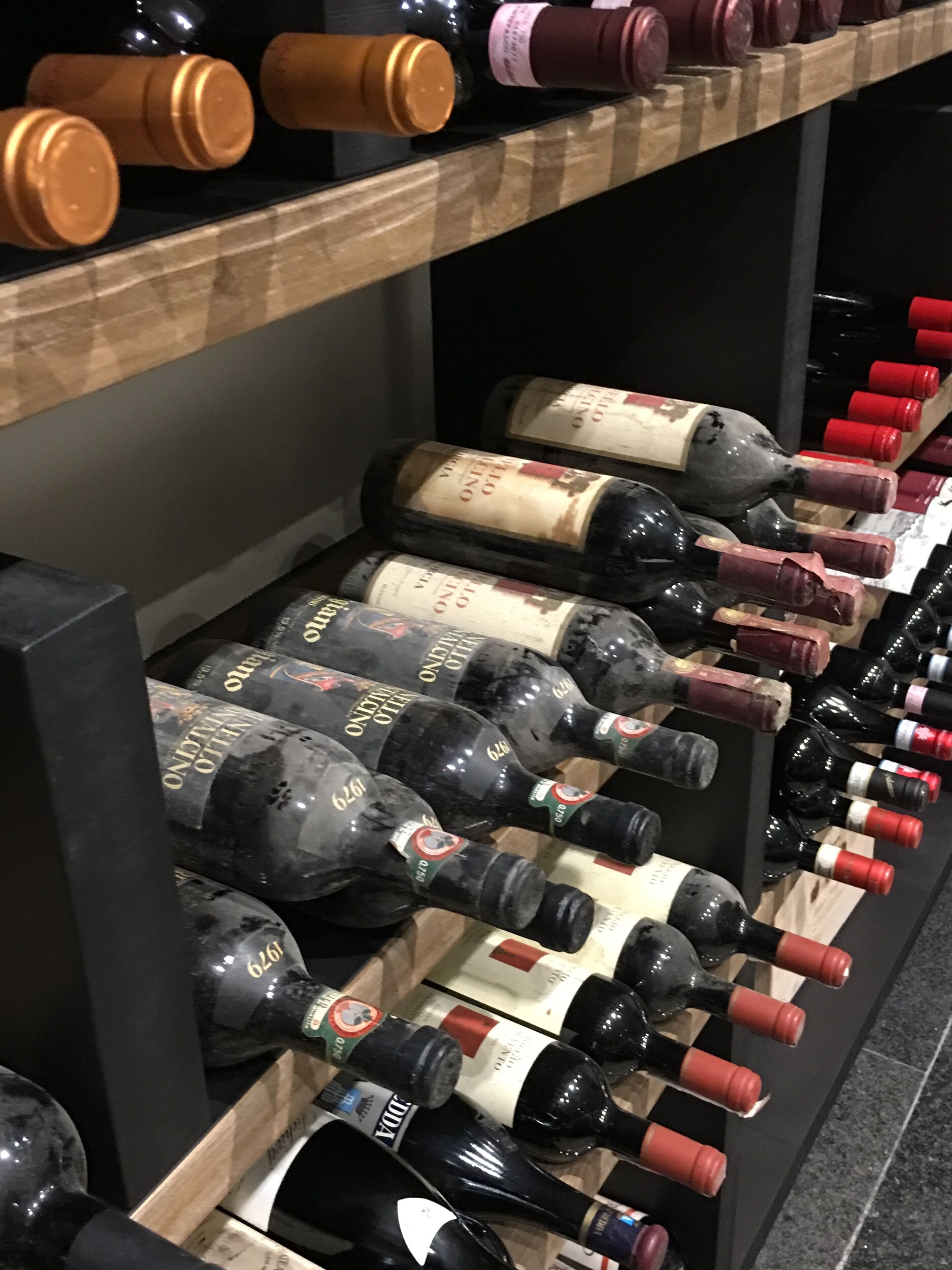 A wine rack with multiple bottles of wine, including some with red and gold labels.