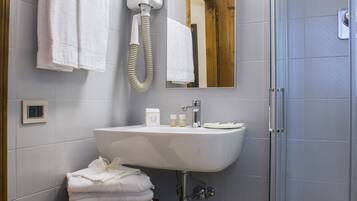 Une salle de bain moderne avec un lavabo, un miroir et une douche.