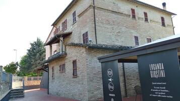 Un bâtiment historique à la façade en briques, doté de nombreuses fenêtres et d’une enseigne avec du texte.