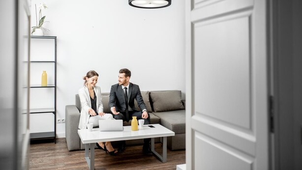 A modern room with a grey sofa, a white coffee table, and a black pendant light. - Apartment Horodotska 4 (Lviv)