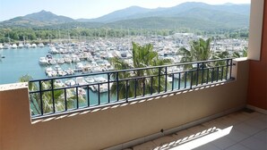 A balcony with a view of a marina and mountains.